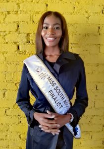 woman standing in front of a yellow brick wall